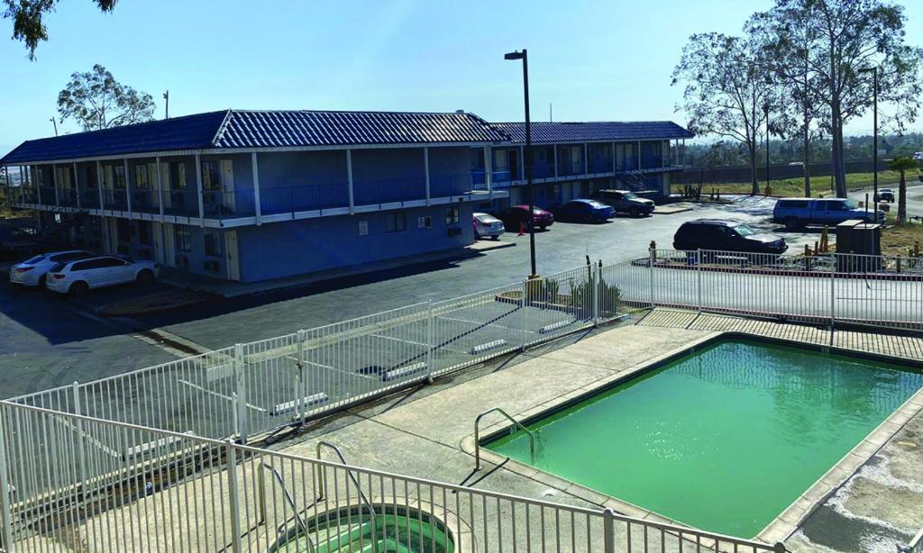 a building with a swimming pool in a parking lot at CIRCLE INN in Riverside