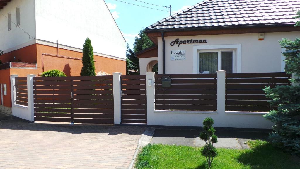 una valla de madera frente a una casa en Rozalia Apartman, en Gyula