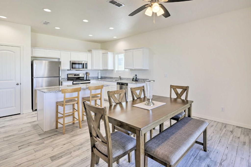 a kitchen with a table and chairs and a kitchen with white cabinets at Modern Kingman Vacation Rental, 5 Mi to Dtwn! in Kingman