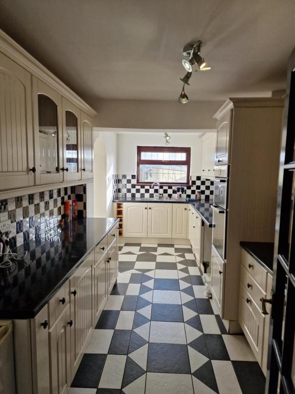 a kitchen with a black and white checkered floor at Shergold House in Swindon