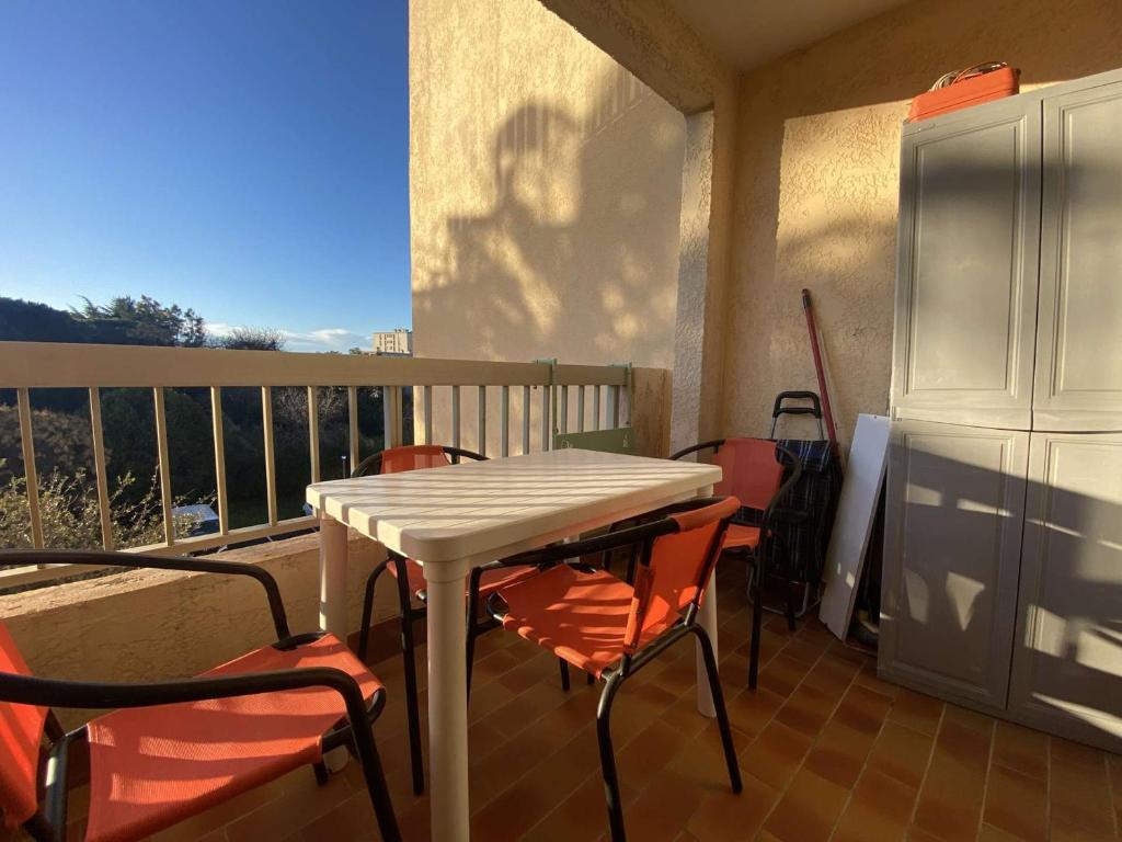 une table blanche et des chaises sur un balcon dans l'établissement Studio cabine avec balcon, piscine et parking - Sainte Maxime - FR-1-226-509, à Sainte-Maxime