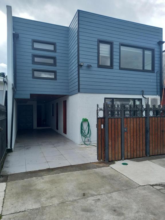 a blue house with a fence in front of it at Cabañas y Departamentos Las Palmas, Temuco Depto 4 in Temuco