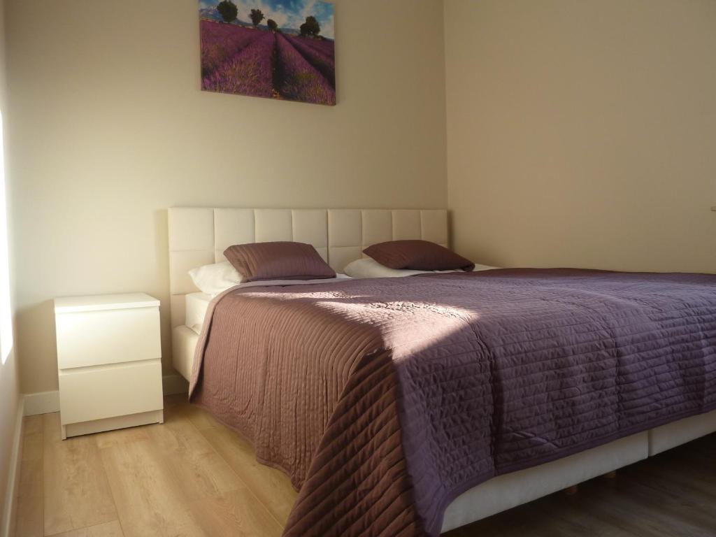 um quarto com uma cama com um edredão roxo em Apartament Zebra em Świeradów-Zdrój