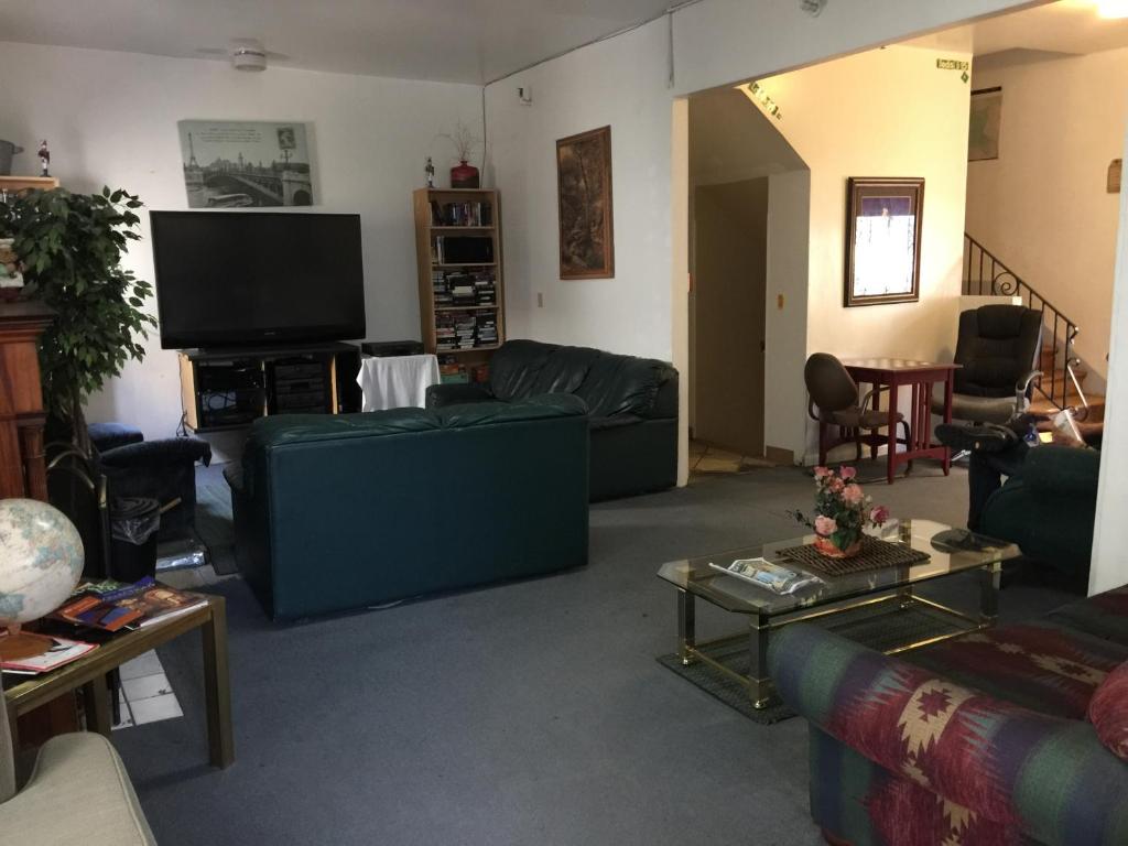 a living room with couches and a flat screen tv at Avenues Hostel in Salt Lake City