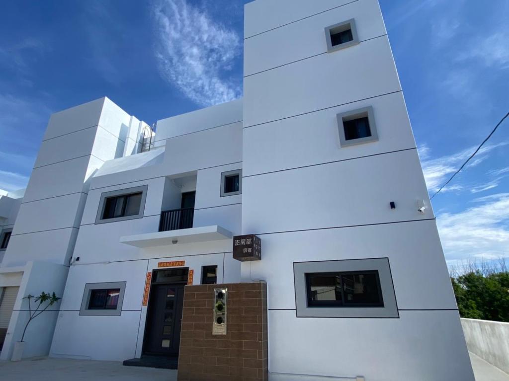 un edificio blanco con una puerta delante en 夏至文旅 Midsummer Guest House, en Magong