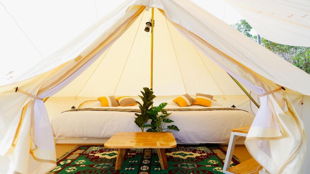 a bedroom with two beds in a canvas tent at The Wild Khao Yai in Klang Dong
