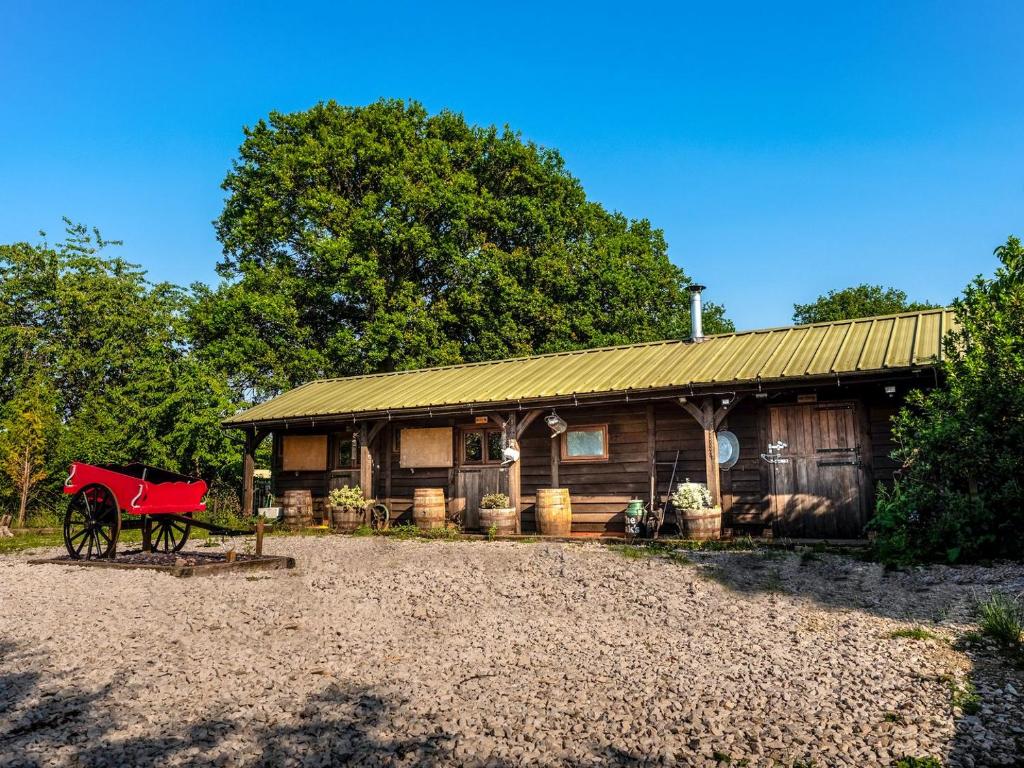 a barn with a red wagon in front of it at The Stables At The Oaks in Hamstall Ridware