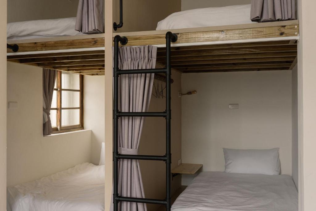 a room with two bunk beds and a ladder at 東衛參捌 陶藝旅店 in Magong