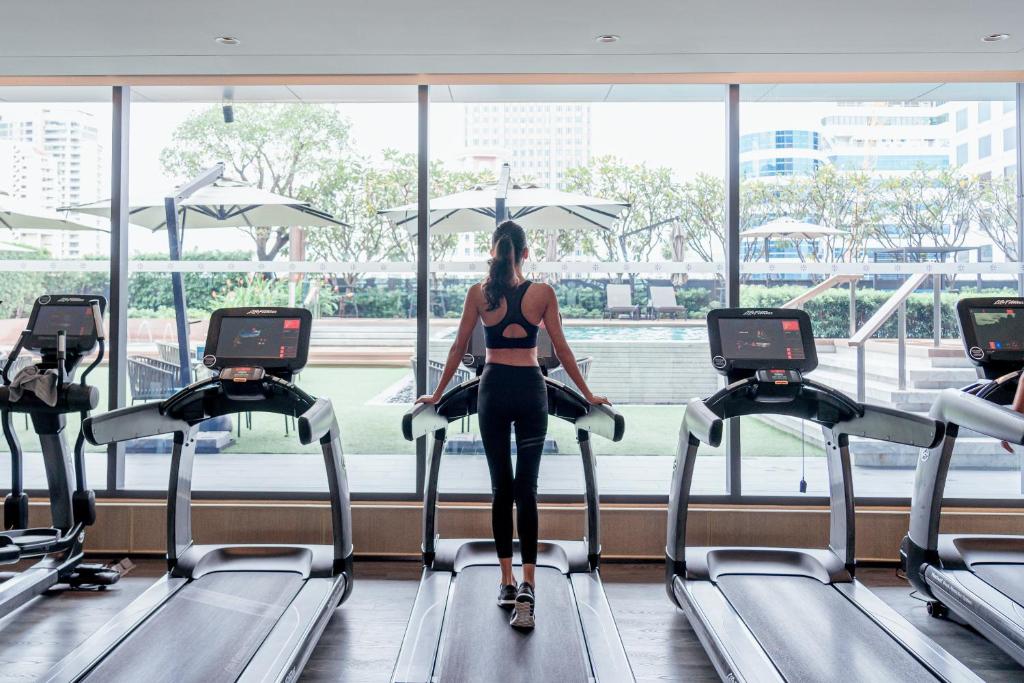 A treadmill workout area overlooking the city and outdoor deck.