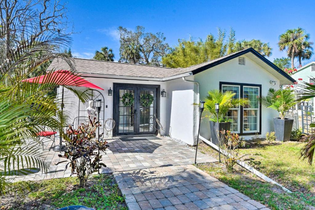 una casa blanca con una puerta y algunas plantas en Florida Getaway with Patio about 3 Mi to Beaches! en New Smyrna Beach