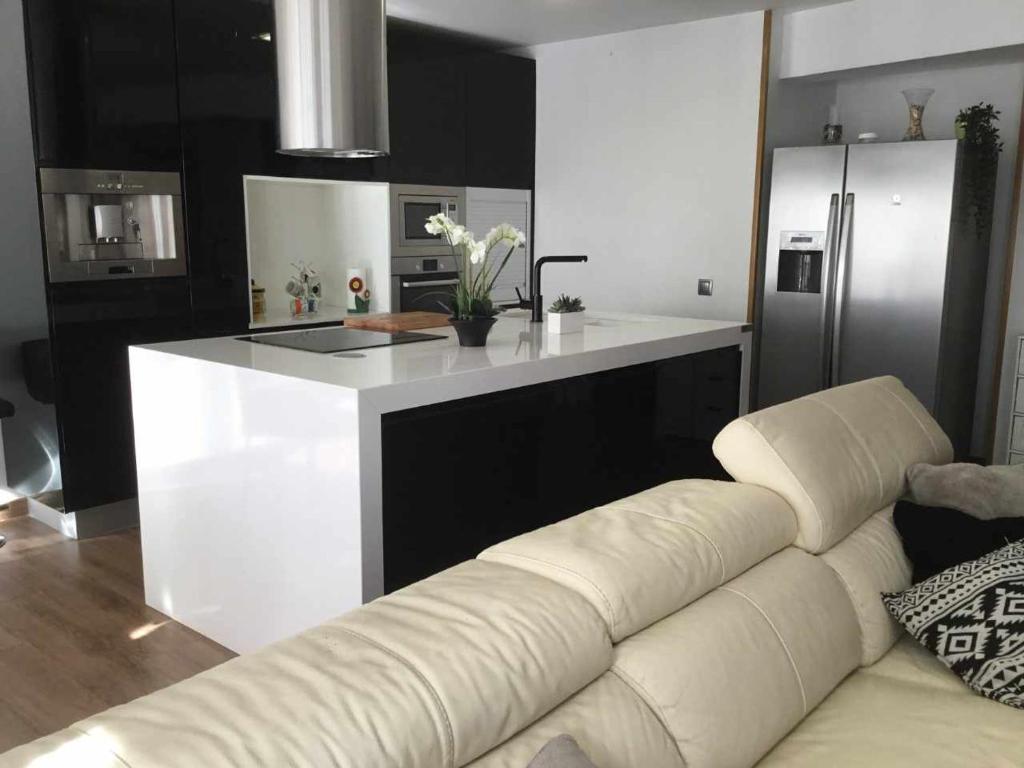 un salon avec un canapé blanc dans une cuisine dans l'établissement Gran piso alto LuzDiseño centrico con garaje, à León