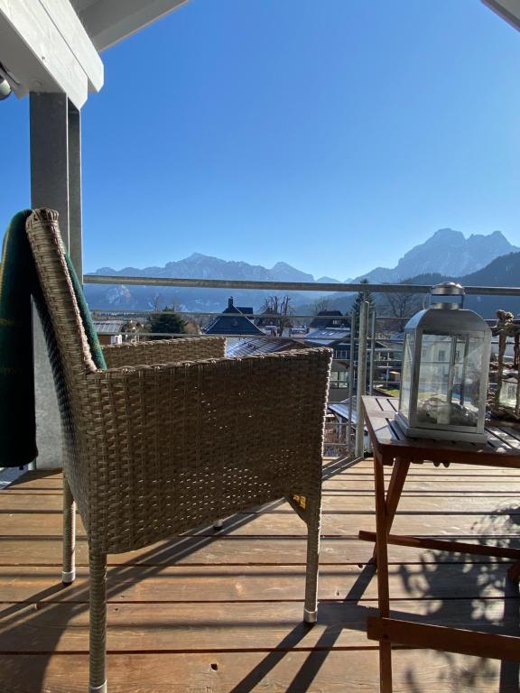 una silla de mimbre sentada en una terraza con una mesa en Penthouse Bargholz, en Füssen