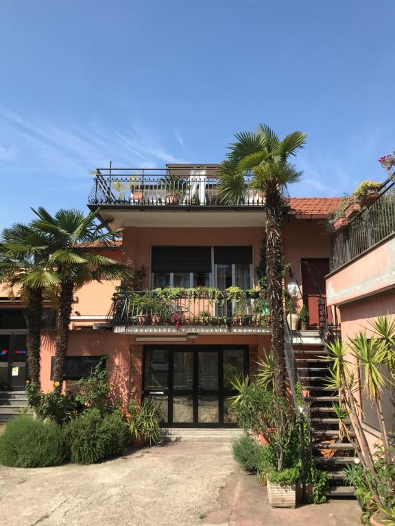 a house with a balcony and palm trees at Appartamento con terrazza e posto auto Libri e Giardini in Pero