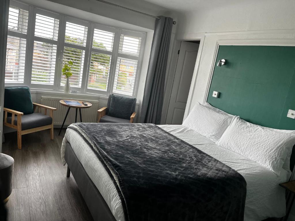 sypialnia z łóżkiem, 2 krzesłami i stołem w obiekcie Orient B&B w mieście Holyhead
