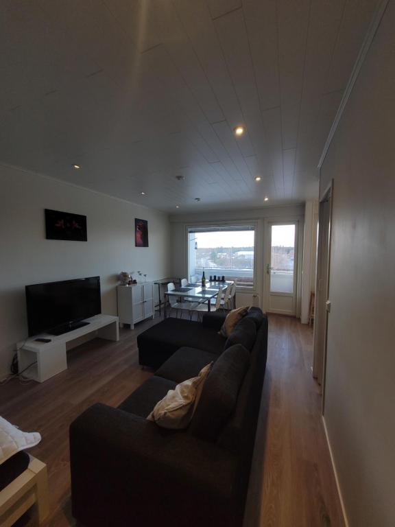 a living room with two couches and a table at Topelius Park Apartment in Uusikaarlepyy