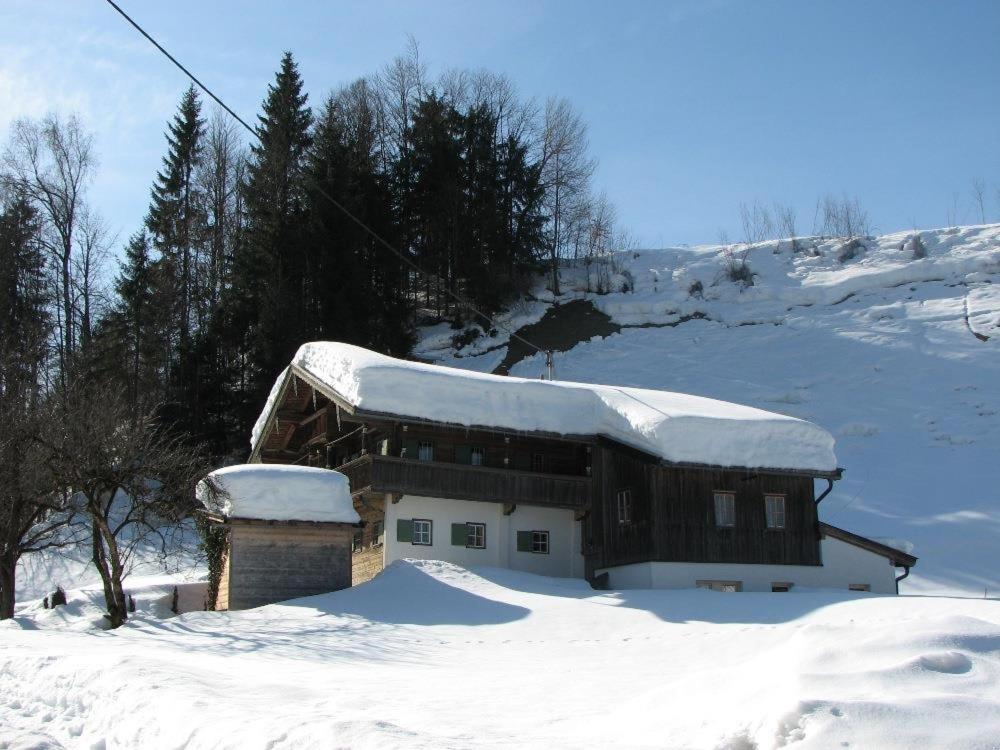 ein Gebäude mit Schnee auf dem Dach im Schnee in der Unterkunft Ferienhaus Lindaubachgütl in Fieberbrunn