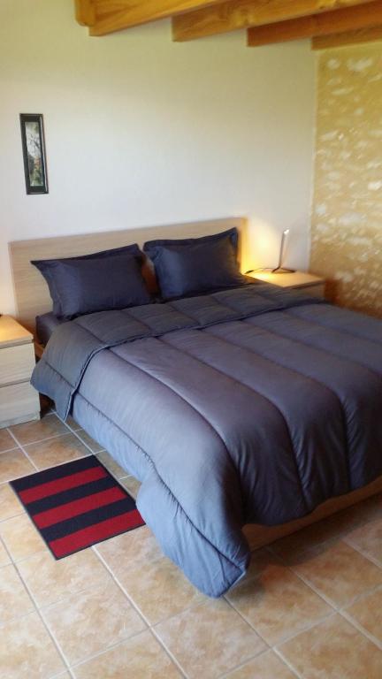 a large bed in a bedroom with a blue bedspread at Domaine Lagardelle Rocamadour in Rocamadour