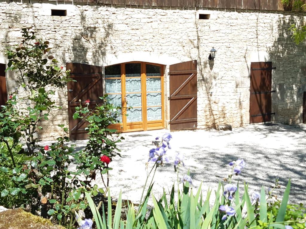 a door to a building with flowers in front of it at Domaine Lagardelle Rocamadour in Rocamadour