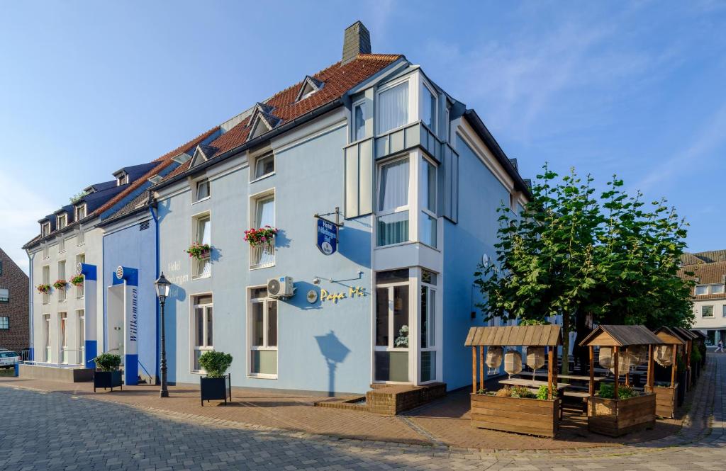 a blue and white building on a street at Hotel Nibelungen Hof in Xanten