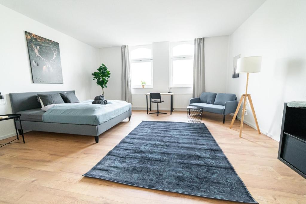 um quarto com uma cama e um sofá em Full House Apartment MCity L10 em Magdeburg