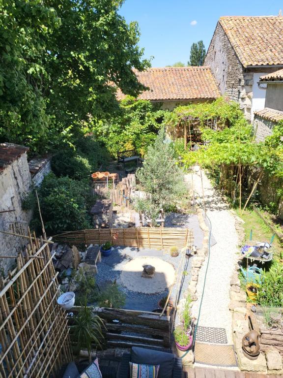 un jardín con una fuente de agua en un patio en Chambre d'Hote Woody, en Chef-Boutonne