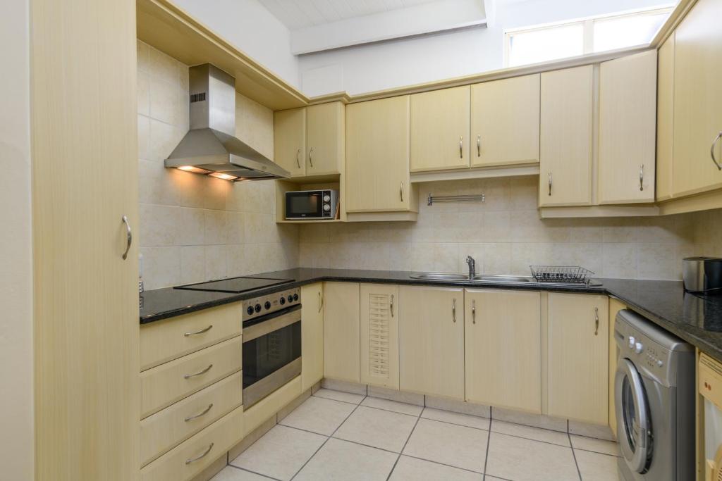 a kitchen with white cabinets and a sink and a dishwasher at San Lameer Villa 2830 - Two bedroom Classic - 4 pax - San Lameer Rental Agency in Southbroom