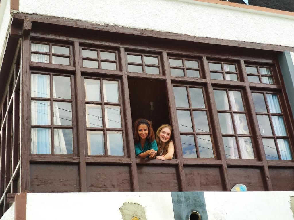 two girls are looking out of a window at Astrostays at Pangong in Spangmik