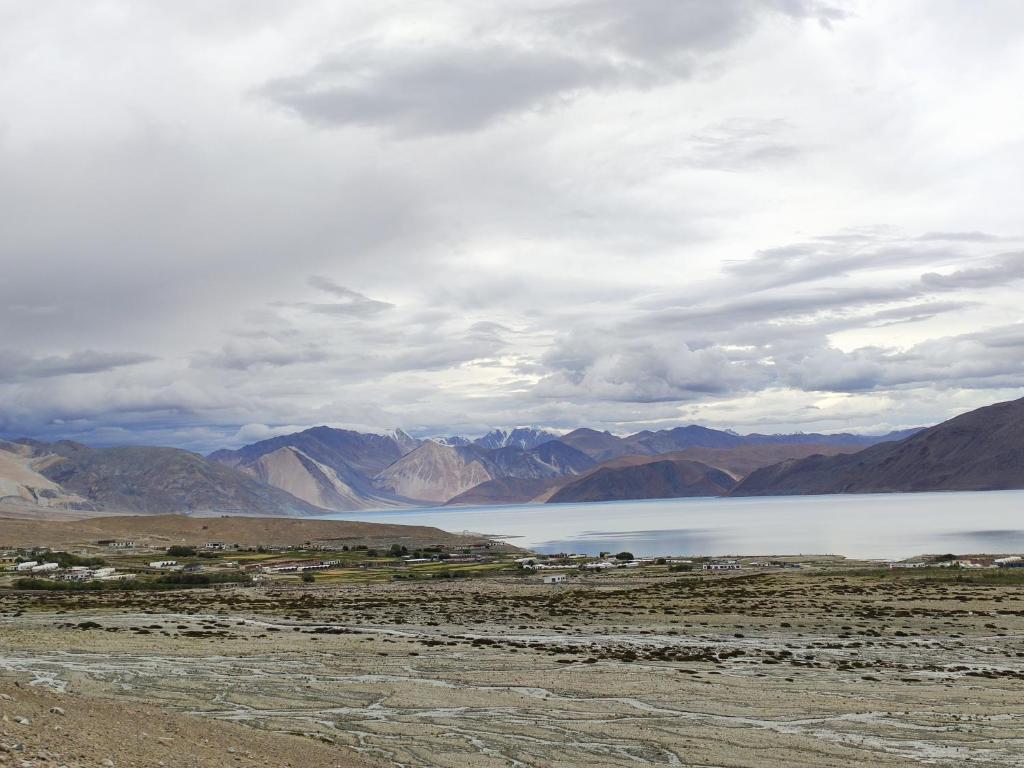 a lake in the middle of a desert with mountains at Astrostays at Pangong in Spangmik