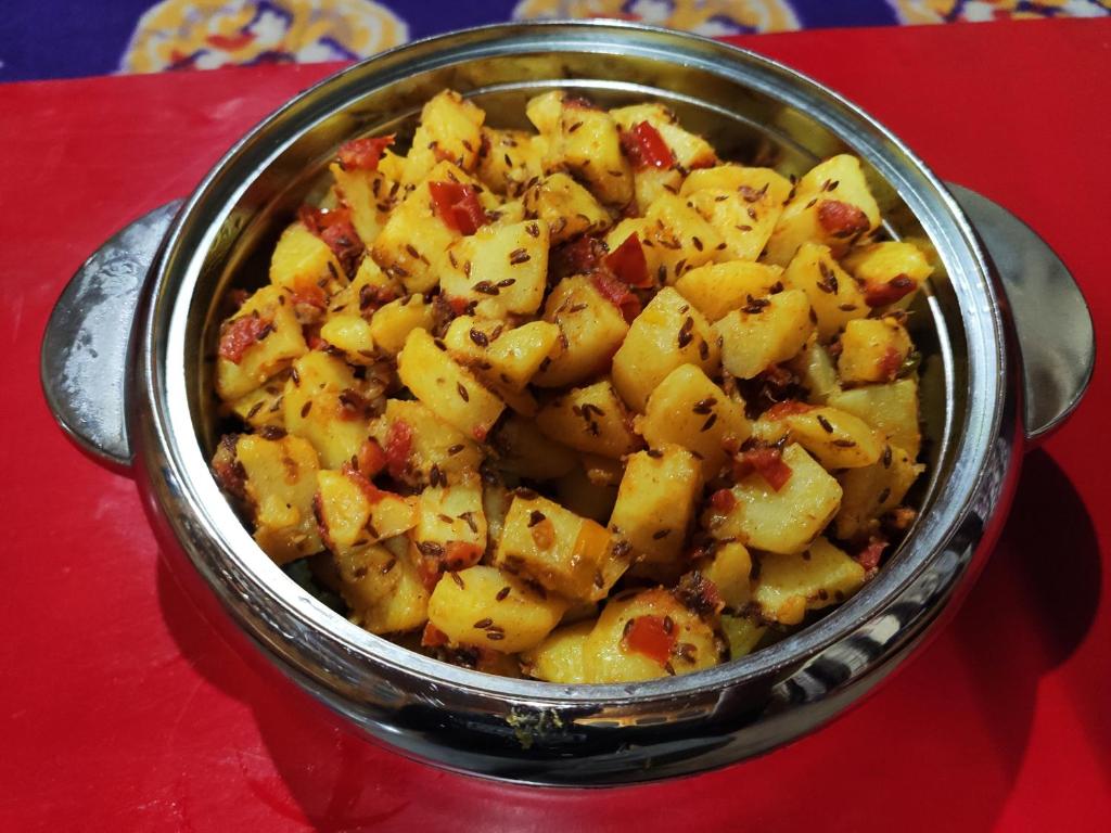 a metal pot filled with potatoes on a red table at Astrostays at Pangong in Spangmik