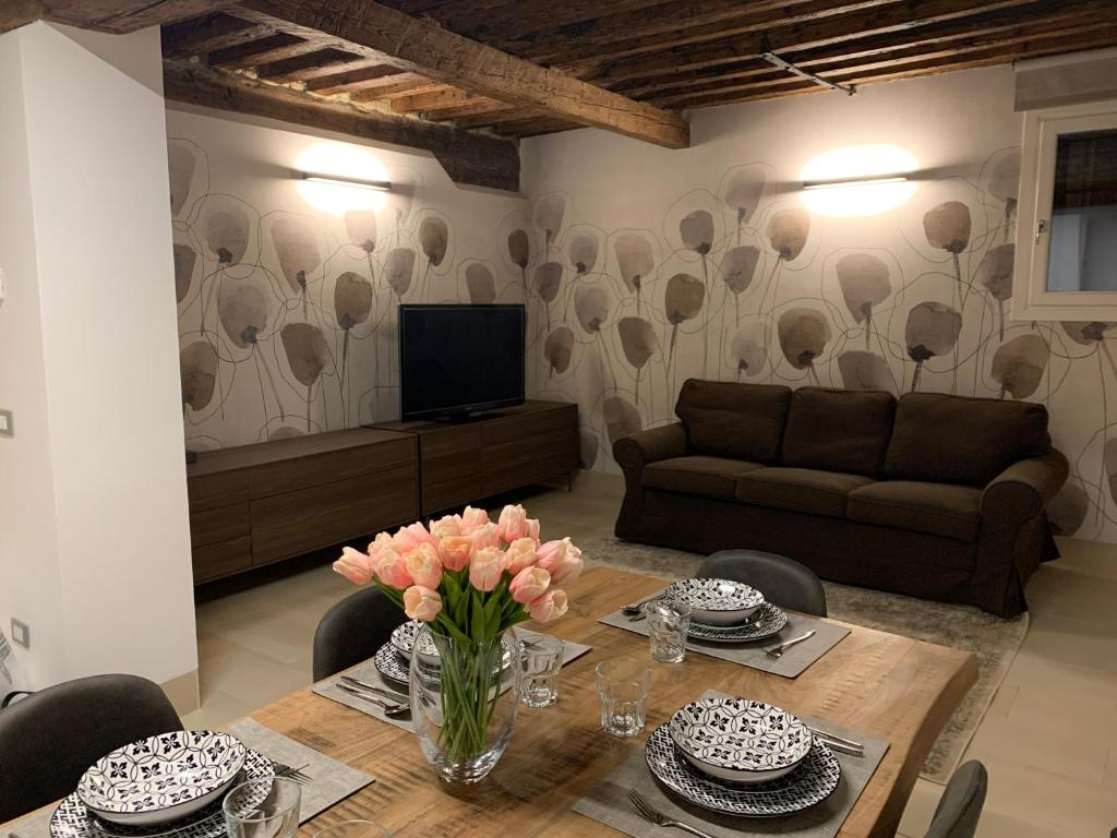 uma sala de estar com uma mesa e um sofá em Ca' Rosa Charming Suite em Veneza