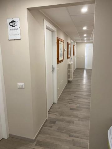 a hallway of an office with white walls and wood floors at Hotel Galla in Milan