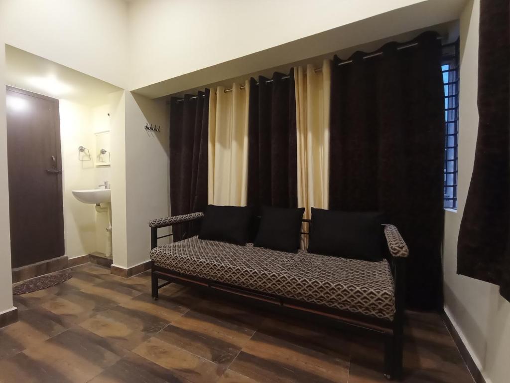 蒂魯吉拉帕利的住宿－Sri Arangan Kudil Rooms，坐在窗户房间里长凳