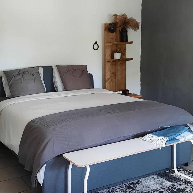 a bedroom with a bed with a bench next to it at Casa Mas Montañas - Gris in Godelleta