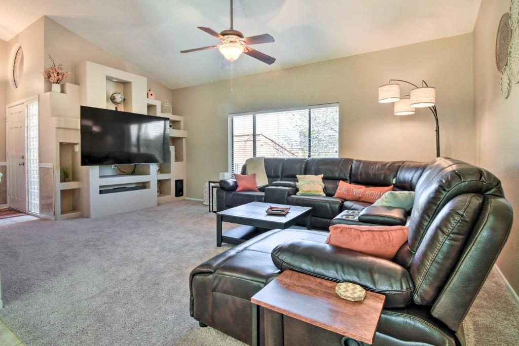 sala de estar con sofá de cuero y TV de pantalla plana en Fountain Hills Retreat with Mtn Views and Pool Access, en Fountain Hills