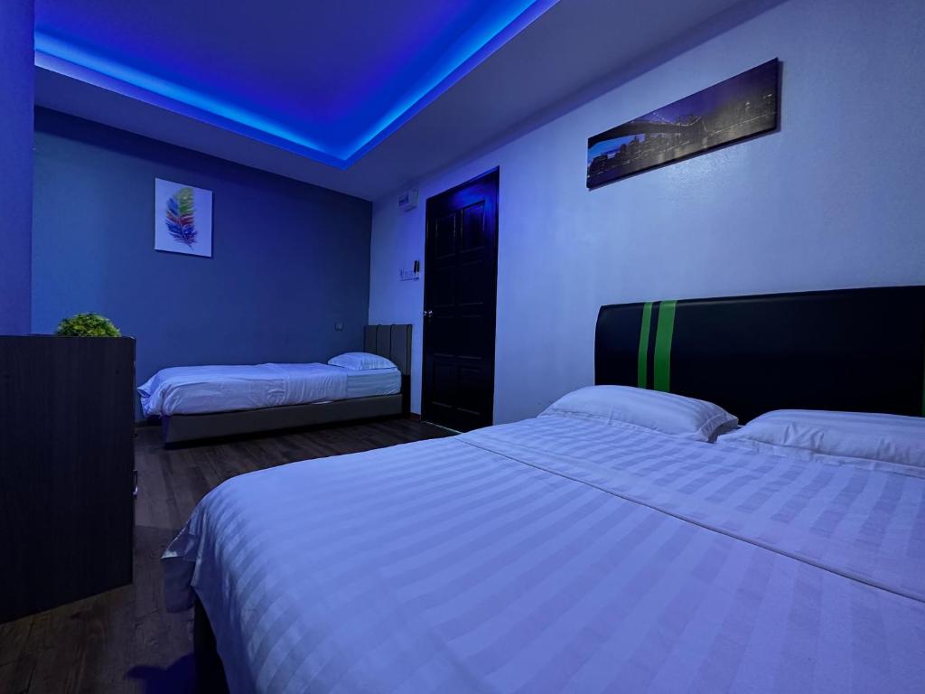 a bedroom with two beds and a blue ceiling at Cow B Homestay Semporna in Semporna