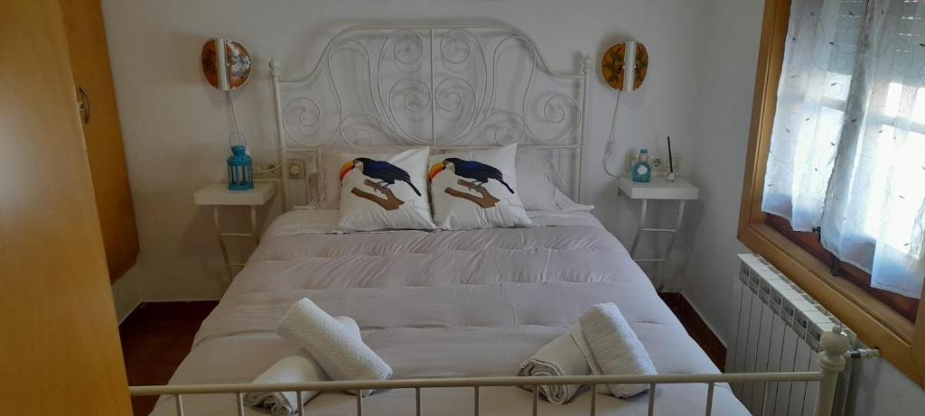 a bedroom with a white bed with two birds on the pillows at CASA la PAU in Vilassar de Mar