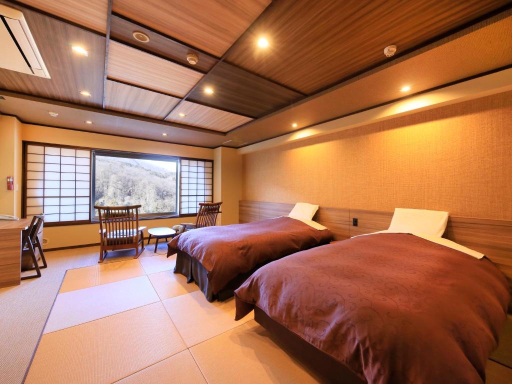 Postel nebo postele na pokoji v ubytování Kishigon Ryokan