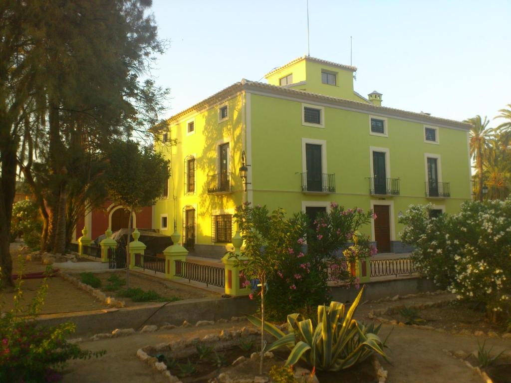 una casa amarilla y verde con una valla alrededor en Ala Mexicana, en Huércal-Overa