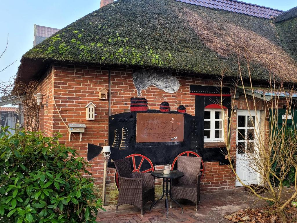 una pequeña casa de ladrillo con techo de hierba en Ferienwohnung Glücklich en Ovelgönne