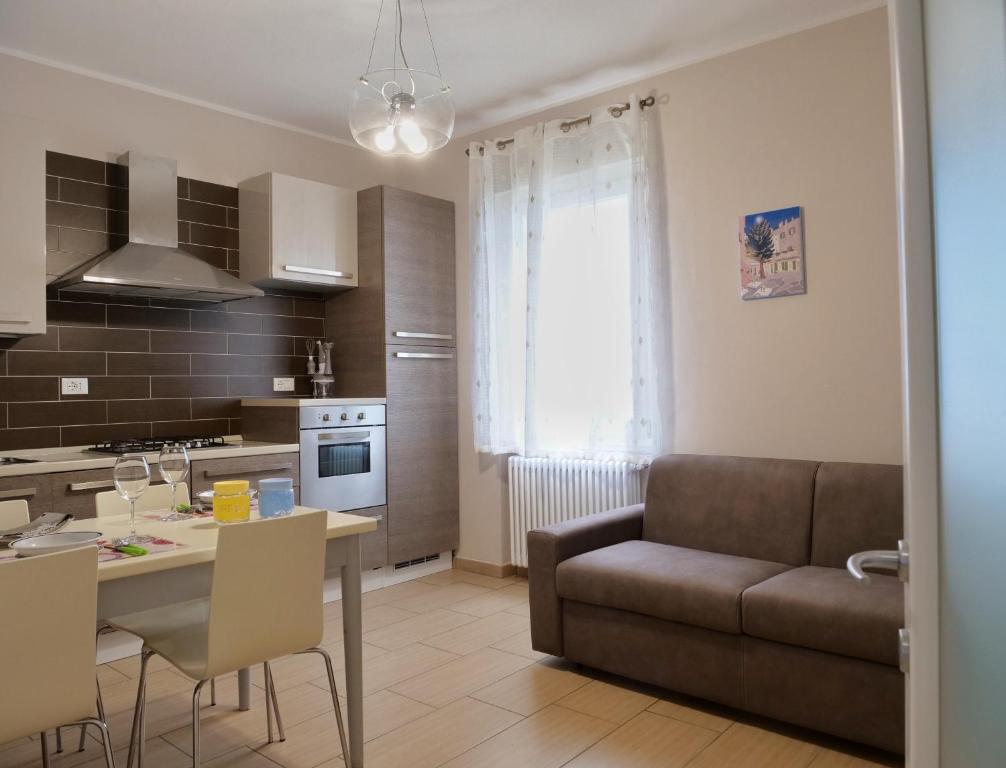 eine Küche und ein Wohnzimmer mit einer Couch und einem Tisch in der Unterkunft Casa Salumiere ‐ BICAMERE con posto auto vicinissimo alla spiagga Costa Azzurra in Grado