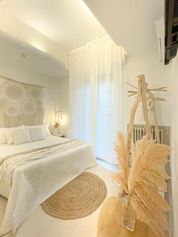 a white bedroom with a bed and a window at Americana Beach House in Rimini