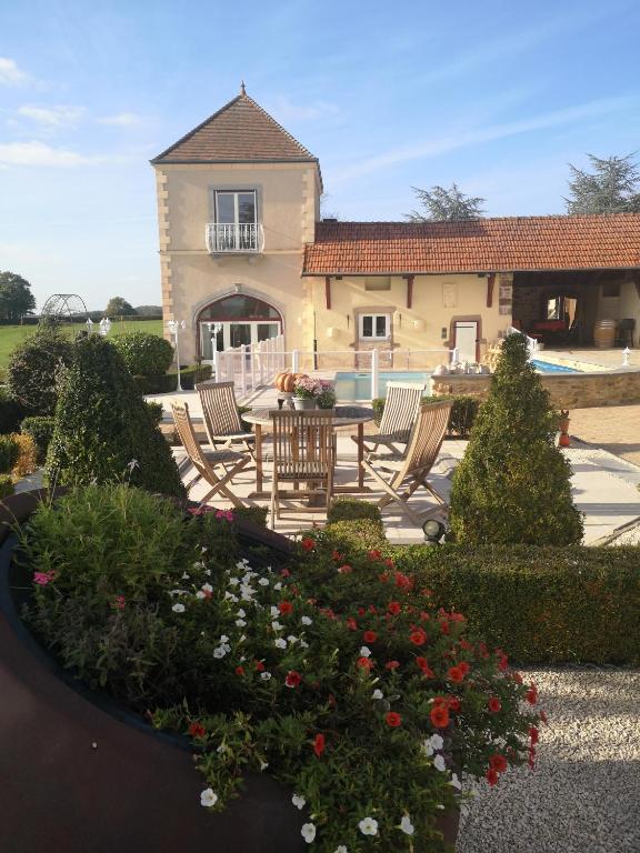 a garden with chairs and flowers in front of a house at La Tour D'Elaine in Essertenne