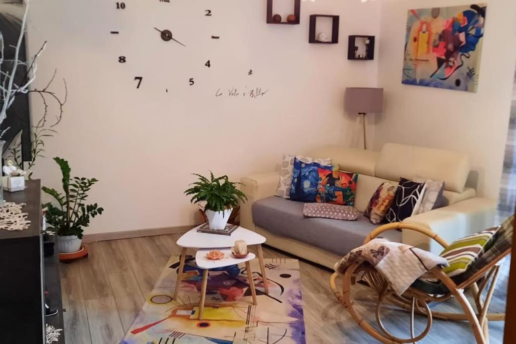 a living room with a couch and a clock on the wall at Ai piedi del Centro Storico in Castiglione del Lago