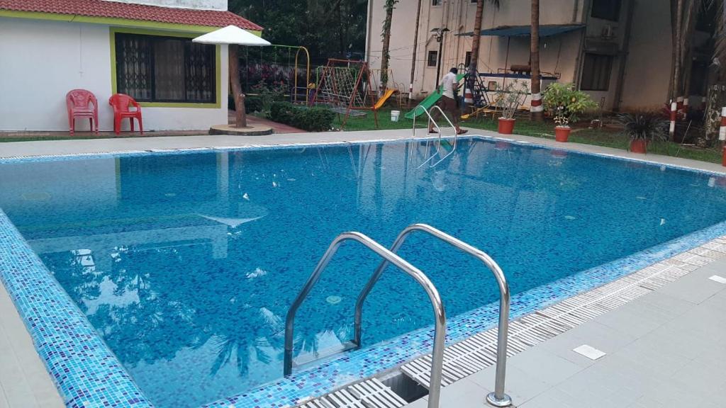 בריכת השחייה שנמצאת ב-Ruturaj Inn Alibag או באזור