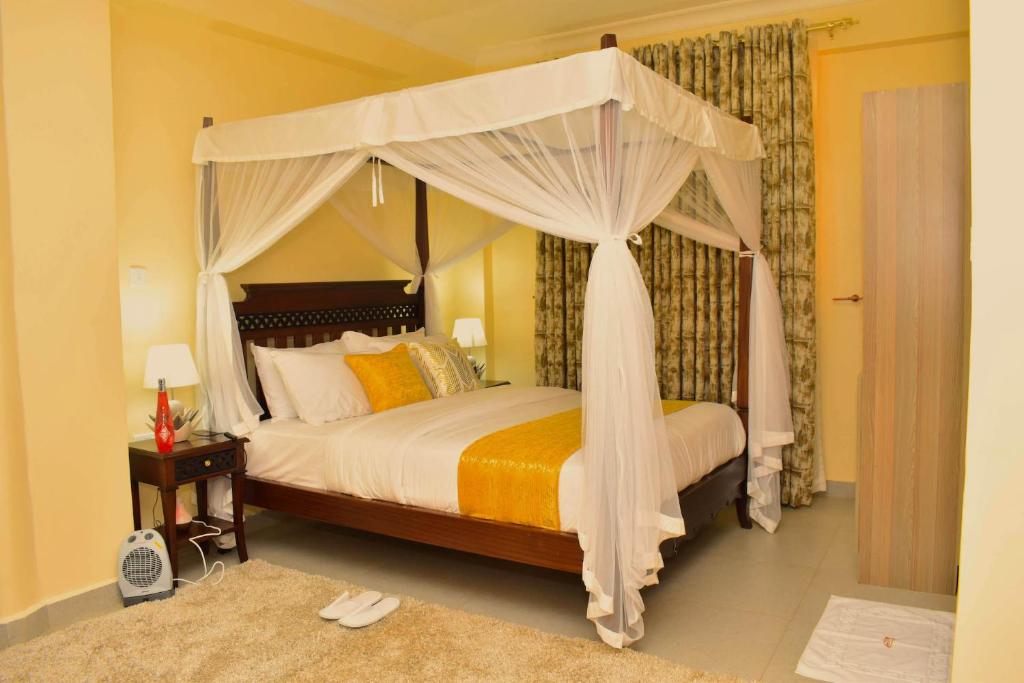 1 dormitorio con 1 cama con dosel en HILLVIEW ECO-TOURISM RESORT, en Bungoma