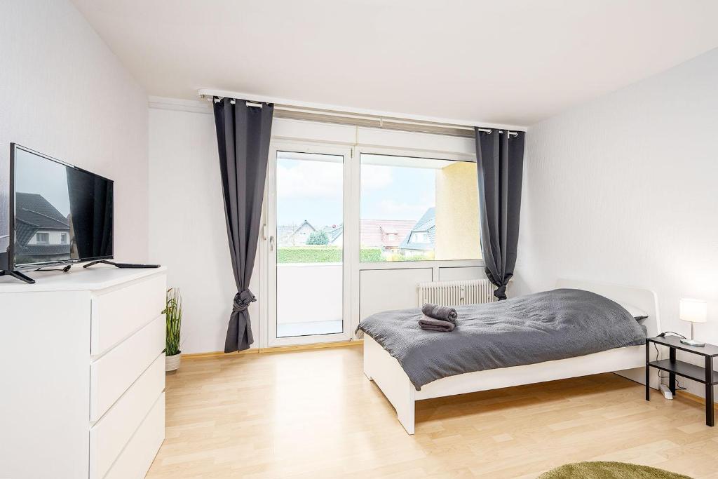 um quarto com uma cama e uma grande janela em Cosy Apartment near Lippstadt em Geseke