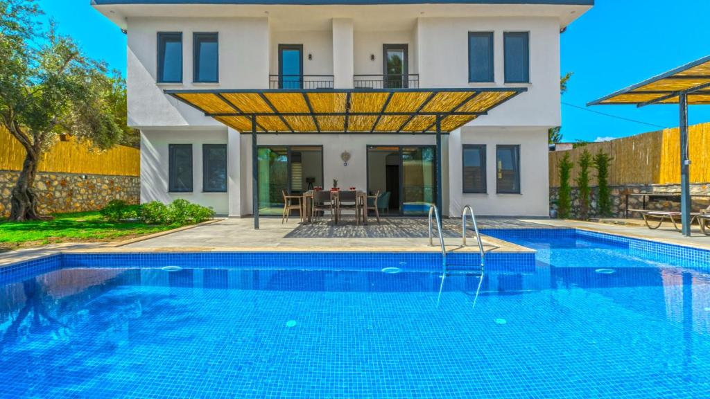 a villa with a swimming pool in front of a house at Villa in Kas with Pool Jacuzzi Garden and Porch in Gelemiş