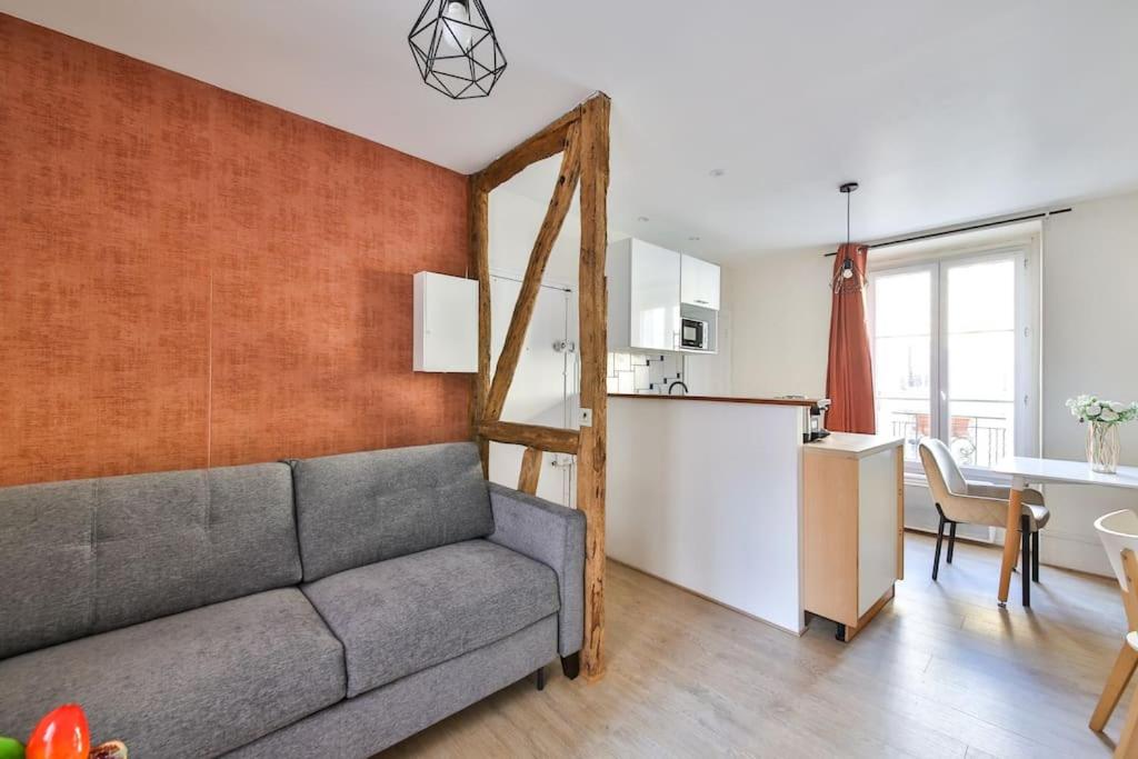 een woonkamer met een bank en een keuken bij 31.Studio 2Pers#Sèvres-Lecourbe#Necker in Parijs