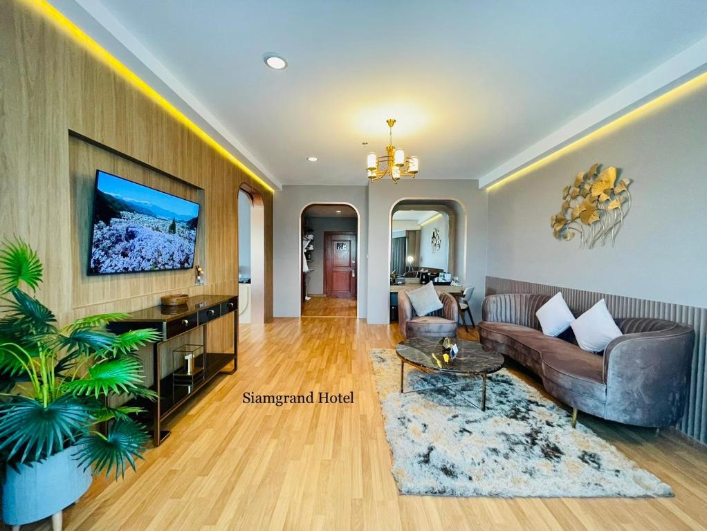 un soggiorno con divano e tavolo di Siamgrand Hotel a Udon Thani
