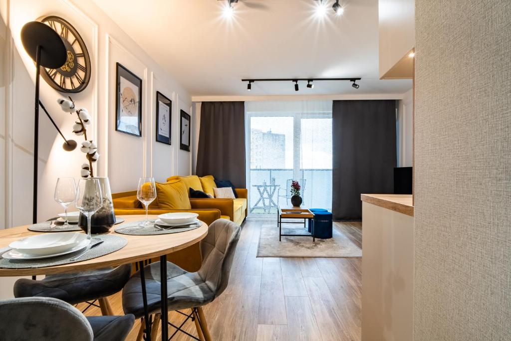 - un salon avec une table et un canapé dans l'établissement ApartamentySnu, Struga Tower Gold z parkingiem, à Radom